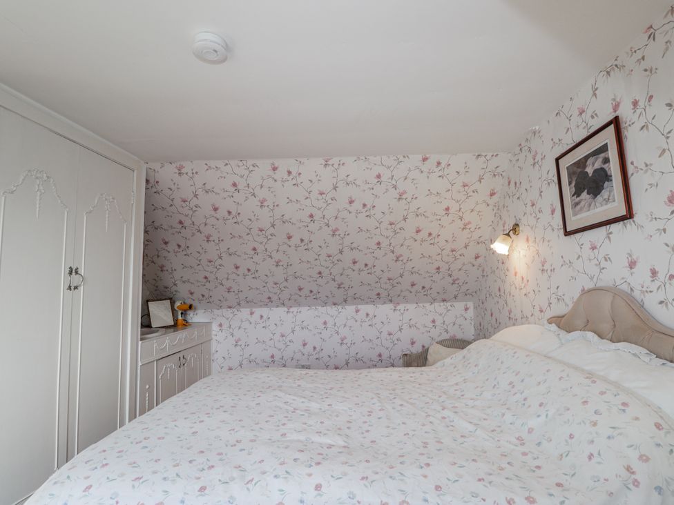 A bedroom with a bed and wardrobe at An Grianan in Kinlochbervie