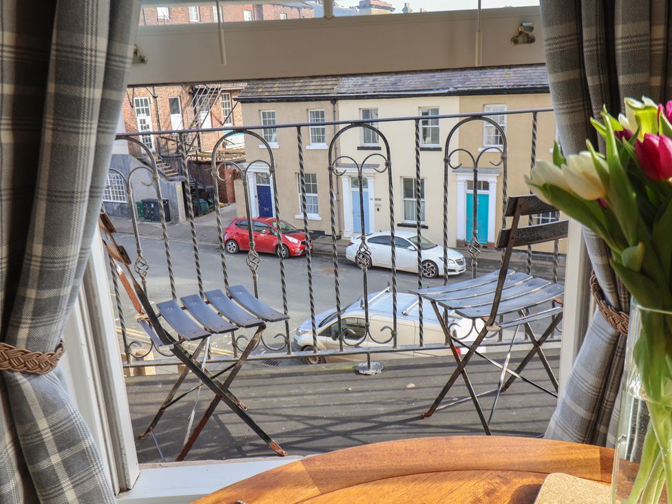 A balcony view with chairs and street scene at Masons Place in Whitby