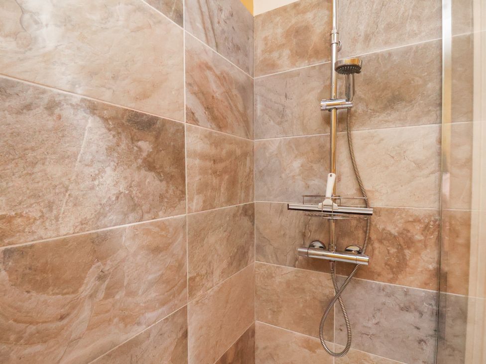 A shower with wall tiles at Masons Place in Whitby