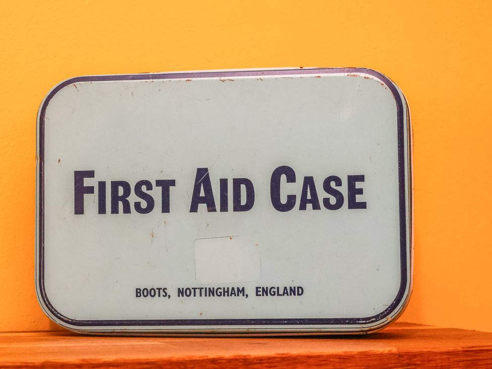 A first aid case on a surface with an orange background at Masons Place in Whitby