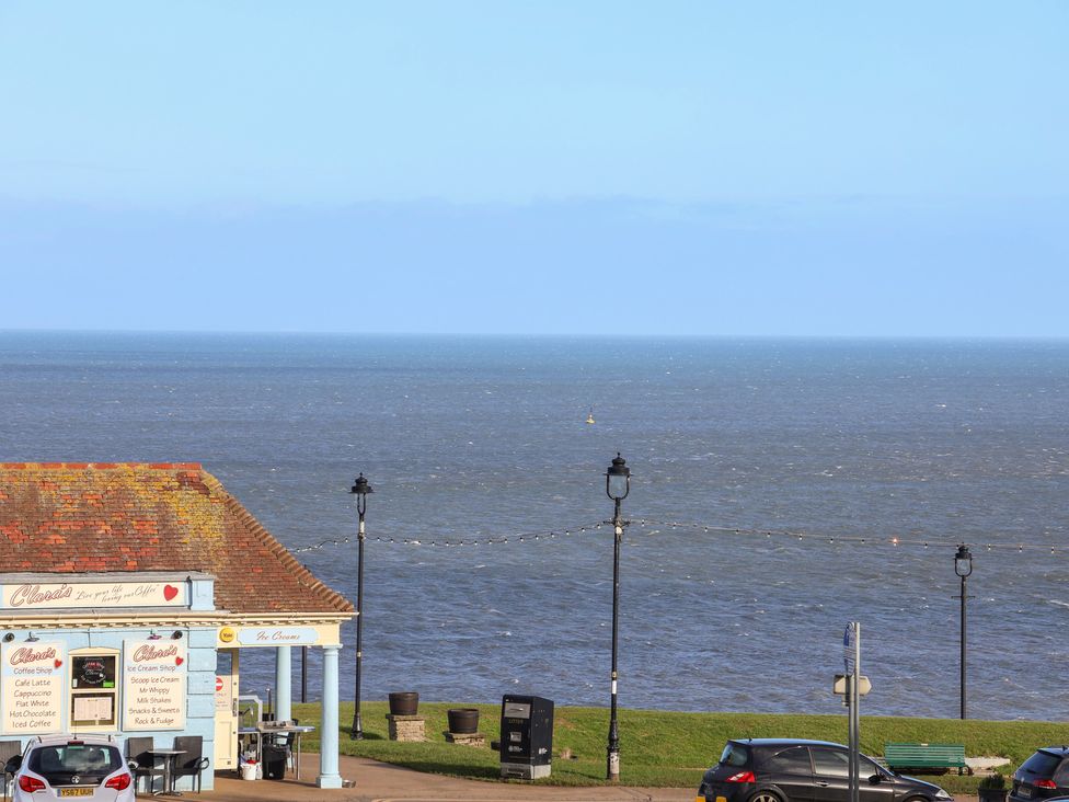 An ocean view with an ice cream shop and street lamps at Masons Place in Whitby