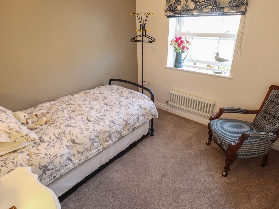 A bedroom with a bed and chair at 4 Eve Street in Louth