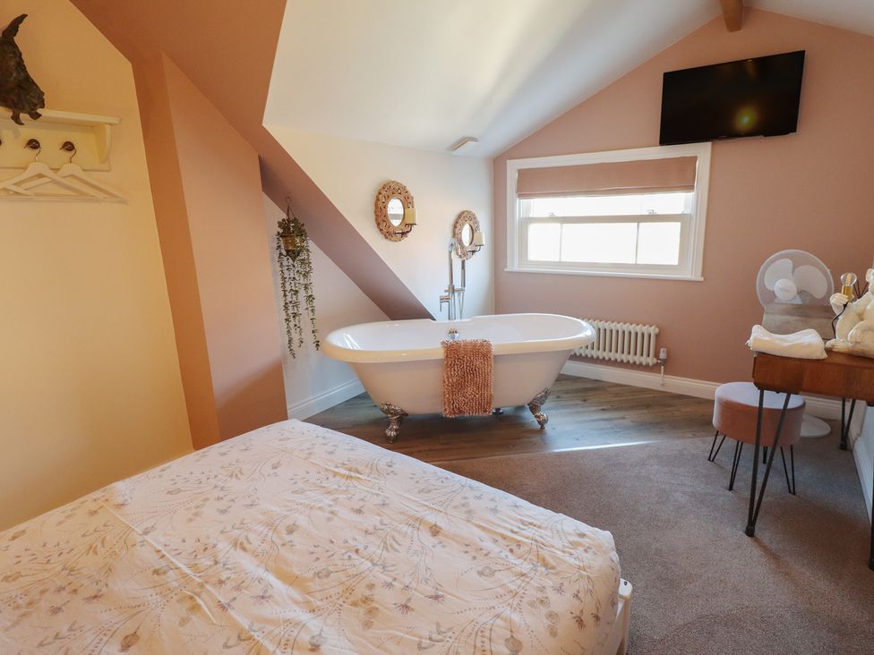 A bathroom with a bathtub and bed at 4 Eve Street in Louth