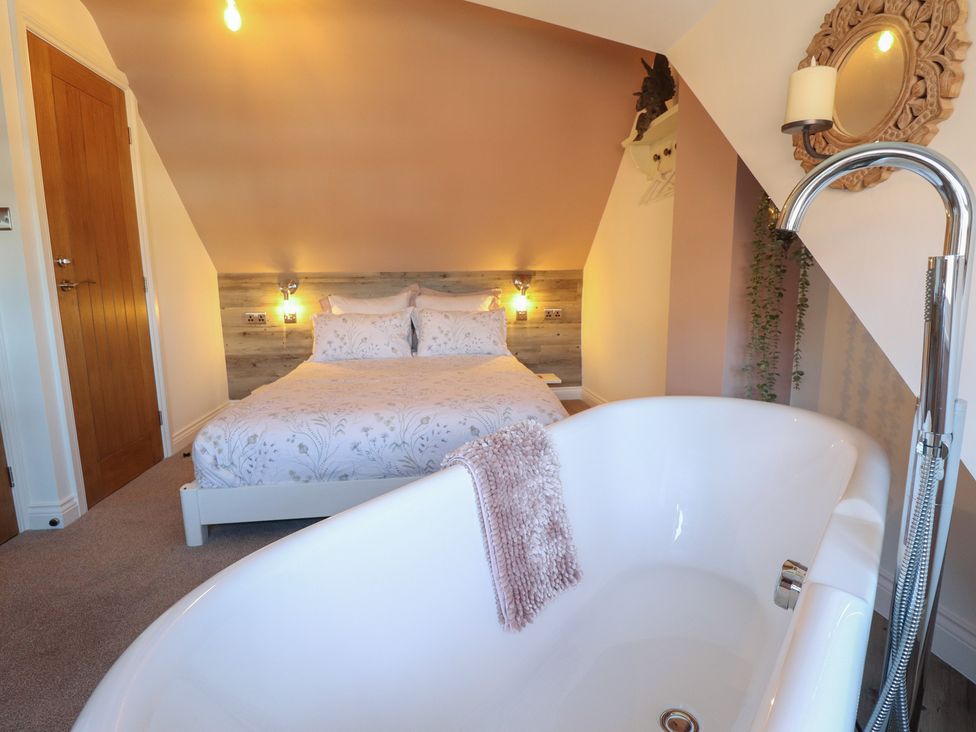 A bedroom with a bed and a bathtub at 4 Eve Street in Louth