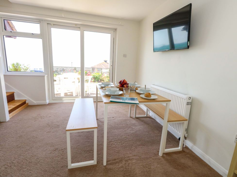 A dining room with a table and chairs at 32 Bowleaze Coveway in Weymouth
