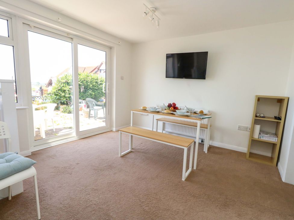 A dining room with a table and chairs at 32 Bowleaze Coveway in Weymouth