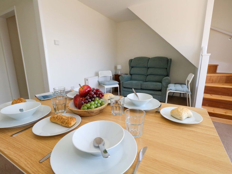 A dining room with a table set for a meal at 32 Bowleaze Coveway Weymouth