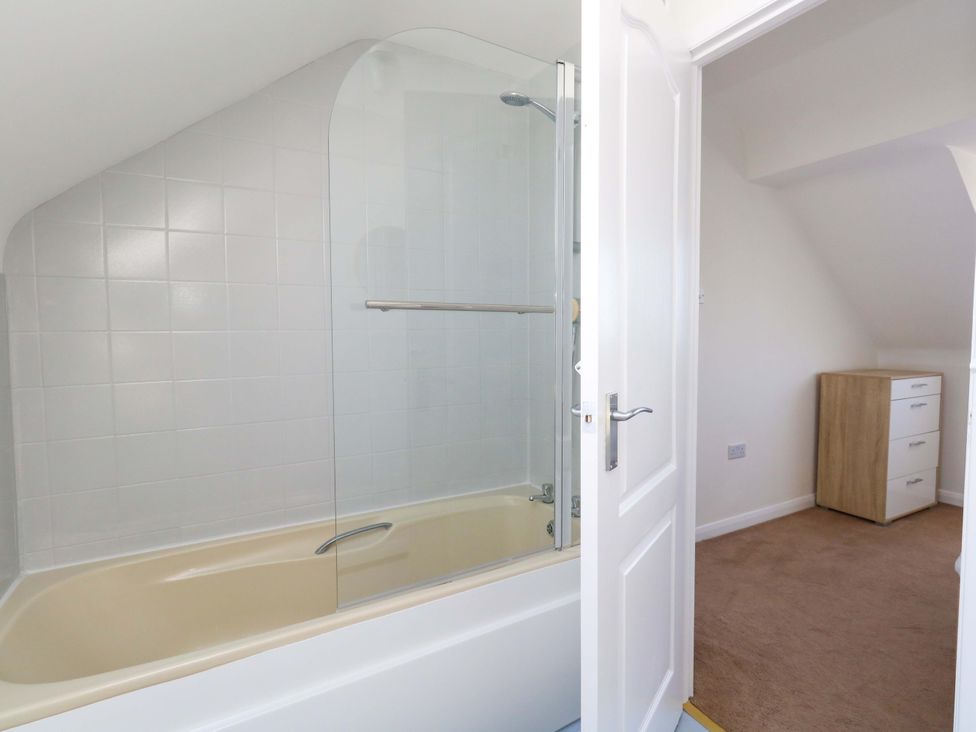 A bathroom with a bathtub and a shower at 32 Bowleaze Coveway in Weymouth