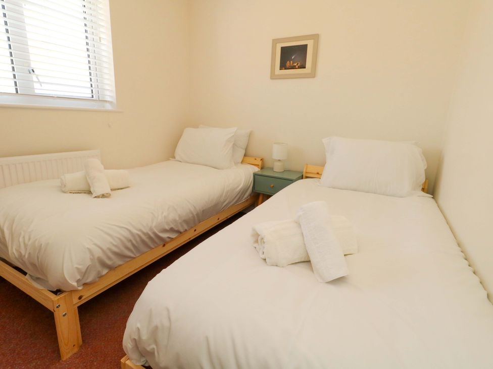 A bedroom with two single beds and towels on the beds at 32 Bowleaze Coveway Weymouth