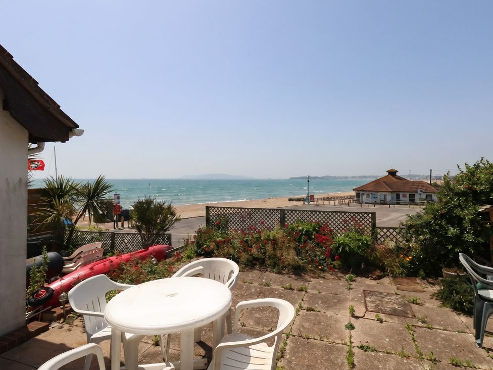 An outdoor area with a table and chairs overlooking the beach at 32 Bowleaze Coveway Weymouth