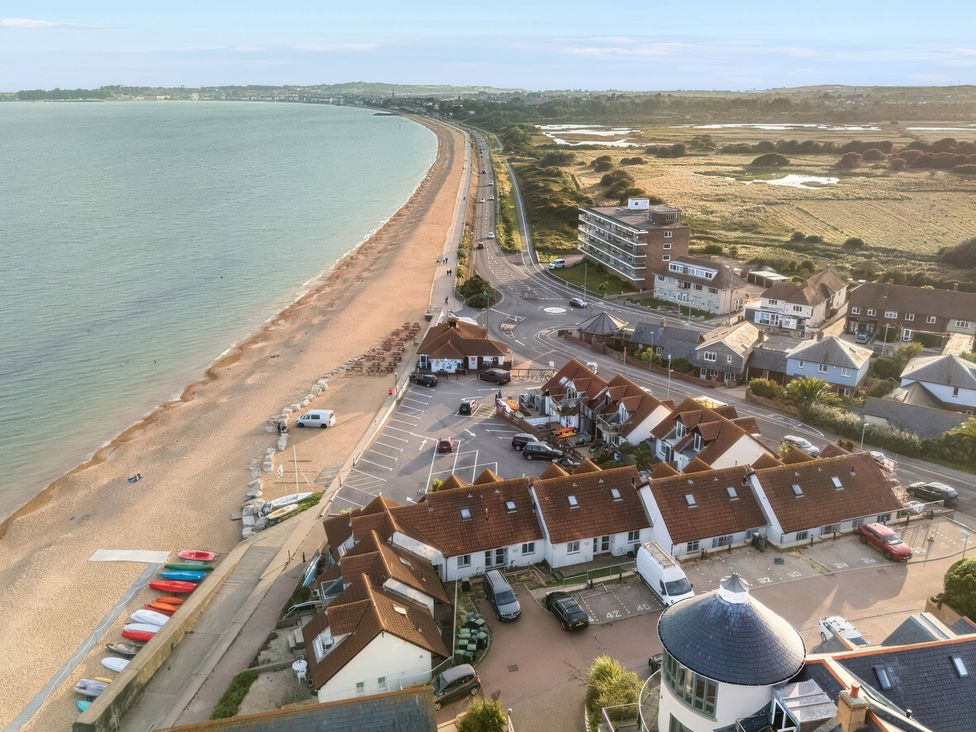 A beach and road with houses and parking at 32 Bowleaze Coveway Preston