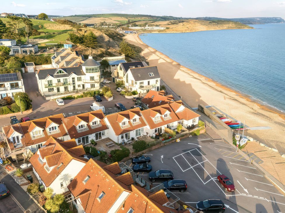 An aerial view of a beach area with buildings and cars at 32 Bowleaze Coveway Preston