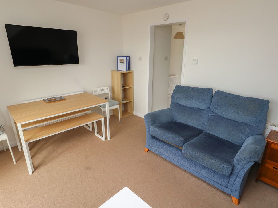 A living room with a sofa and dining table at Bella Rosa in Preston
