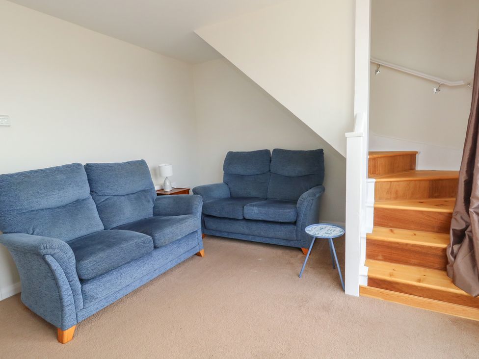 A living room with sofas and a staircase at Bella Rosa in Preston
