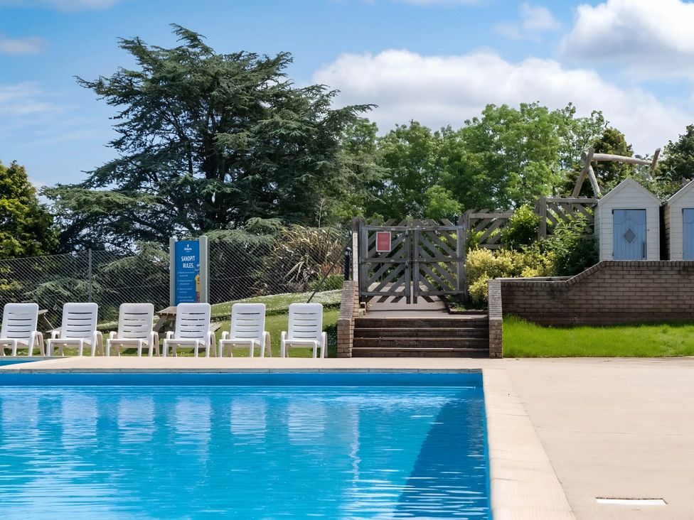 A swimming pool with poolside chairs at Static Caravan Hoburne Devon Bay in Paignton
