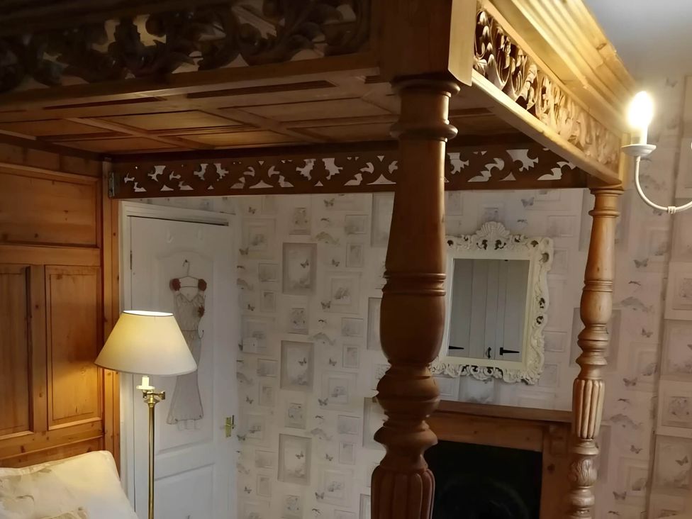 A bedroom with a wooden bed frame and lamp at House - Sleeps 7 - Garden - Pets Ok - Parking Torquay