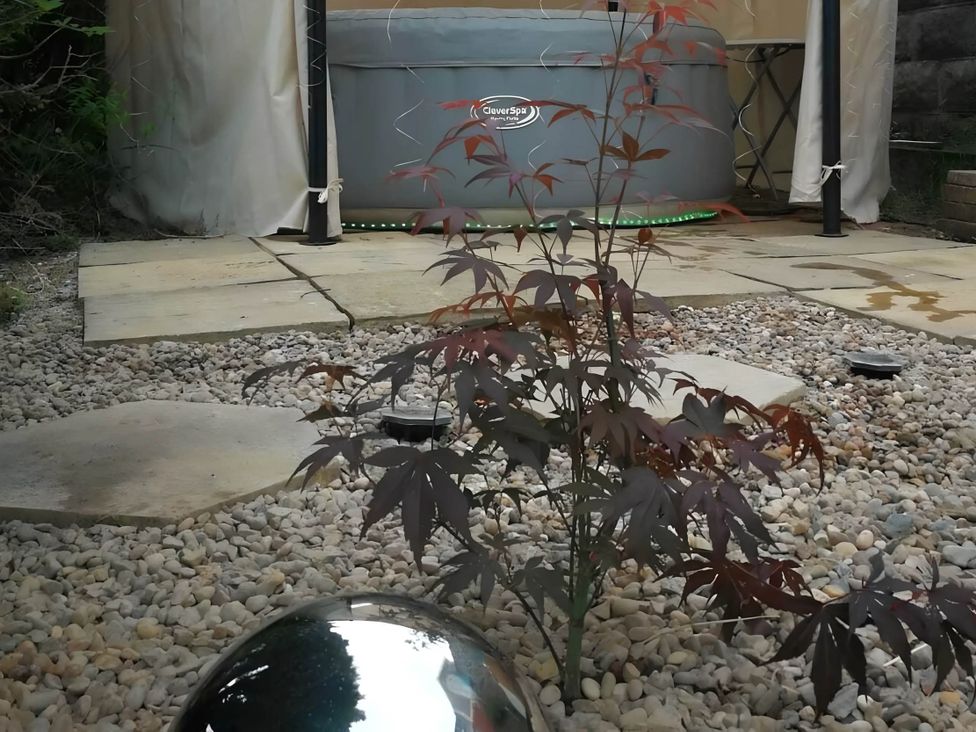 A garden with a hot tub and a small plant at House - Sleeps 7 - Garden - Pets Ok - Parking in Torquay