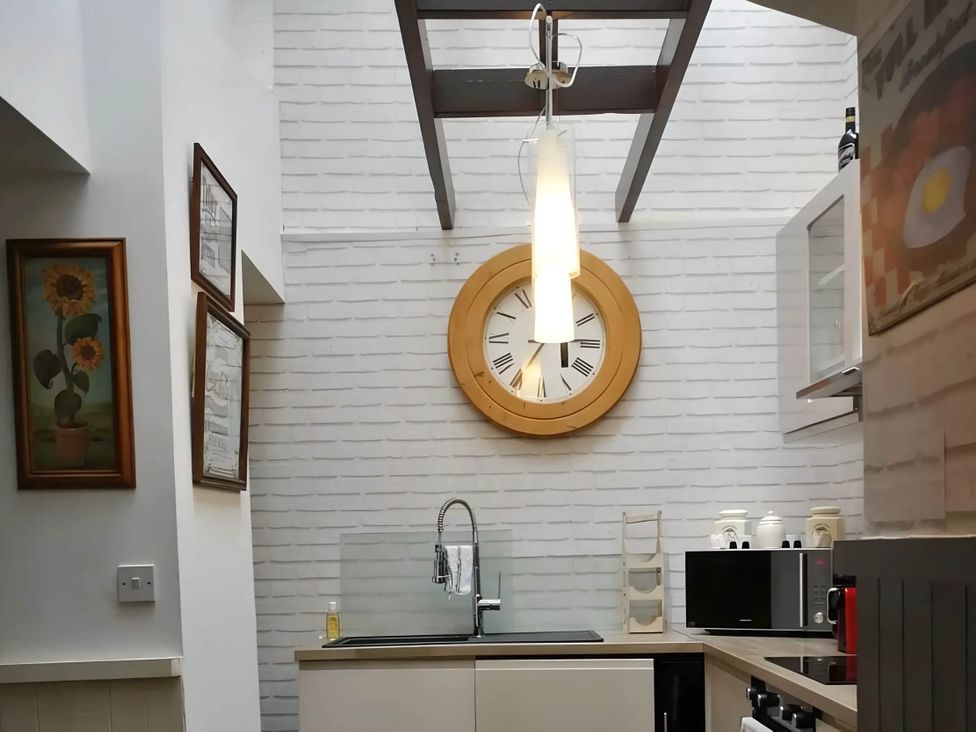 A kitchen with a clock and sink at House - Sleeps 7 - Garden - Pets Ok - Parking in Torquay