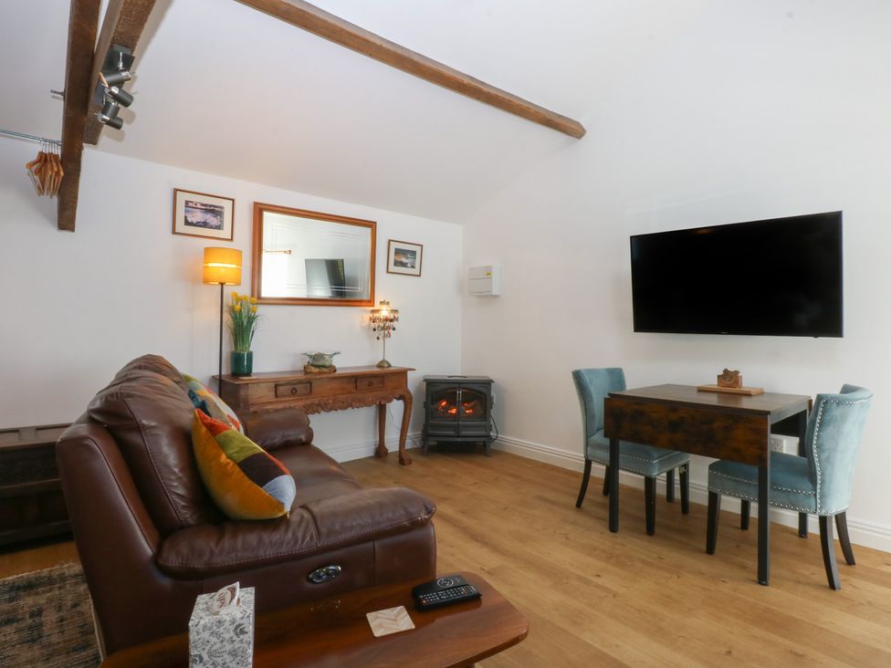 A living room with a sofa and dining table at Studio near Bontnewydd