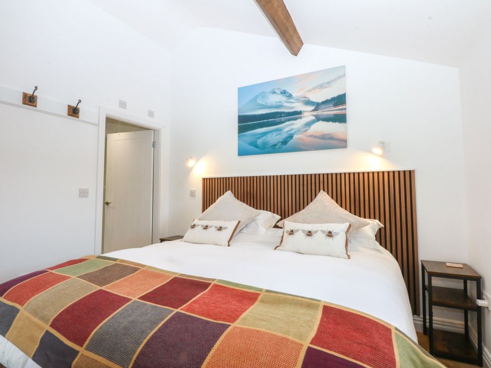 A bedroom with a bed and wall art at Studio near Bontnewydd