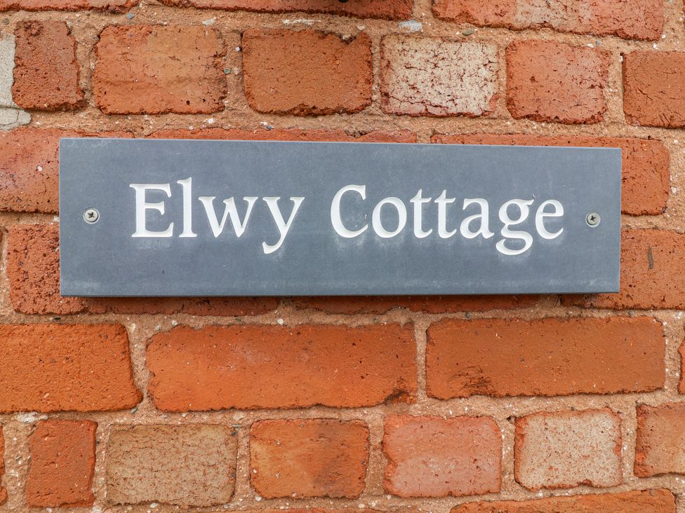A sign reading Elwy Cottage on a brick wall at Elwy Cottage St. Asaph
