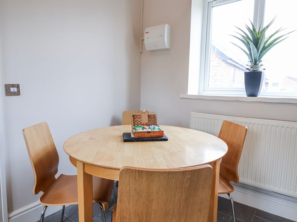 A dining room with a round table and four chairs at Elwy Cottage in St. Asaph