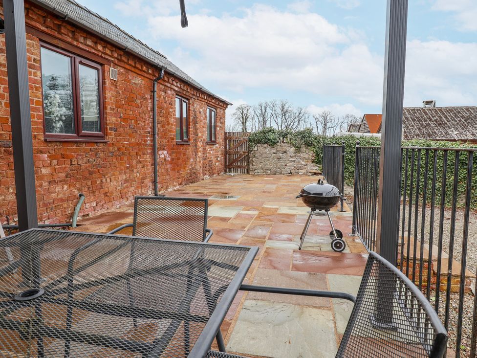 A garden with a table and chairs and a barbecue grill at Elwy Cottage St. Asaph