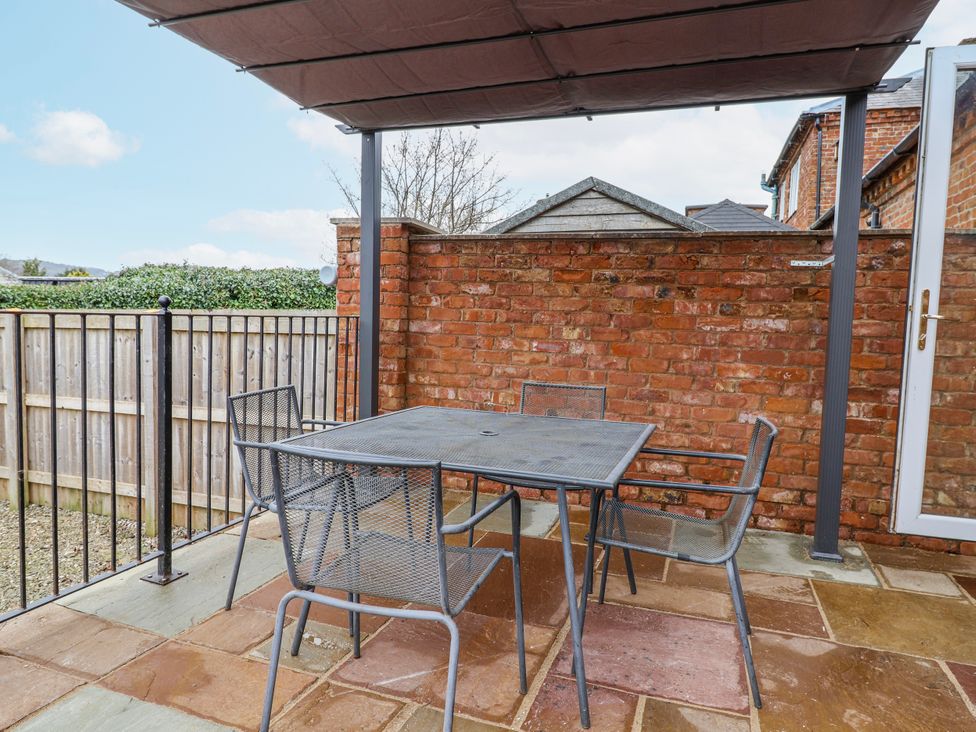 An outdoor seating area with a table and chairs at Elwy Cottage St. Asaph