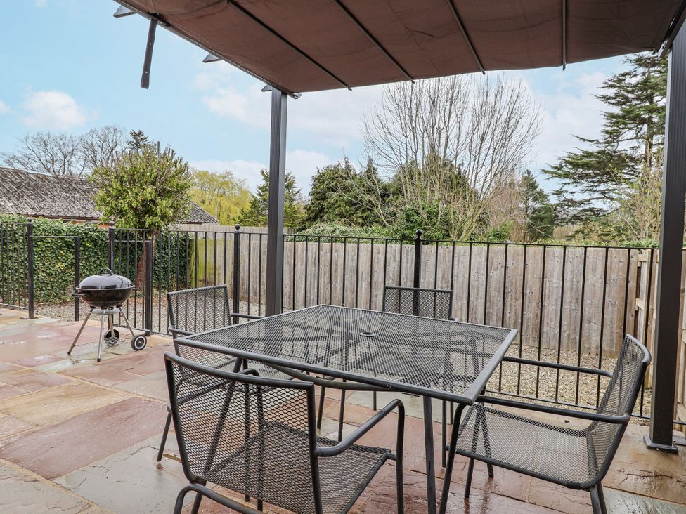 An outdoor patio with a table and chairs at Elwy Cottage in St. Asaph