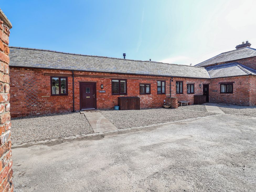 An outdoor area with a brick building and gravel pathway at Elwy Cottage in St Asaph