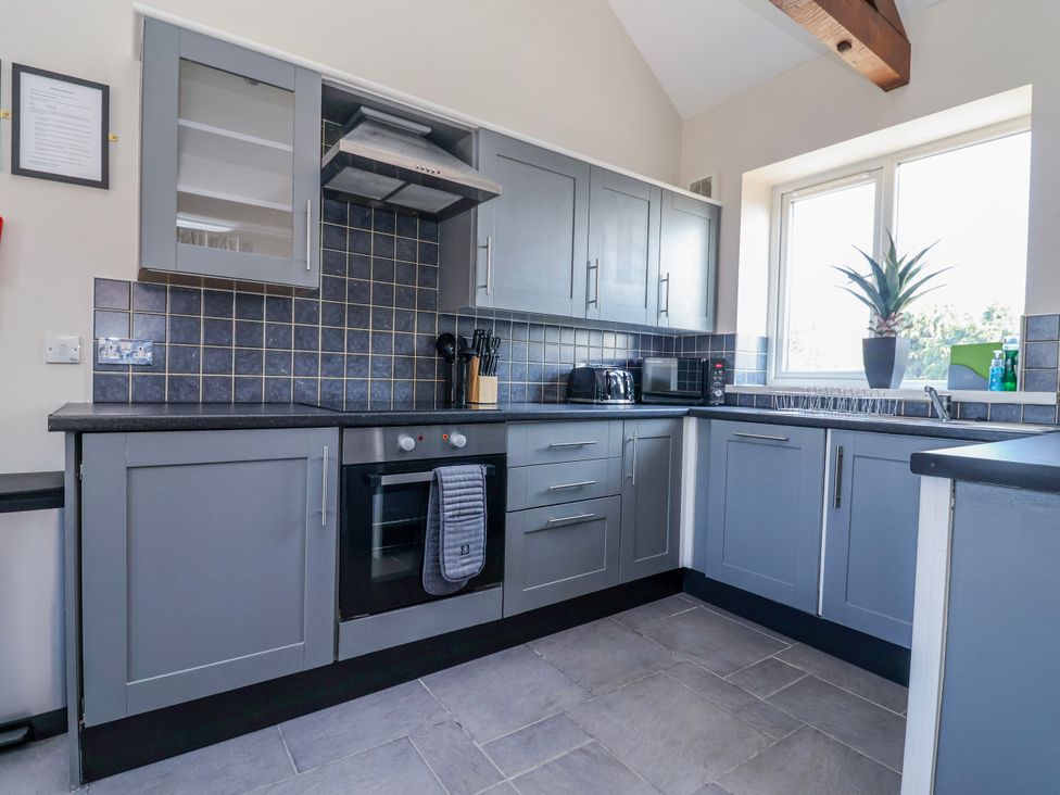 A kitchen with cabinets and appliances at Elwy Cottage in St Asaph