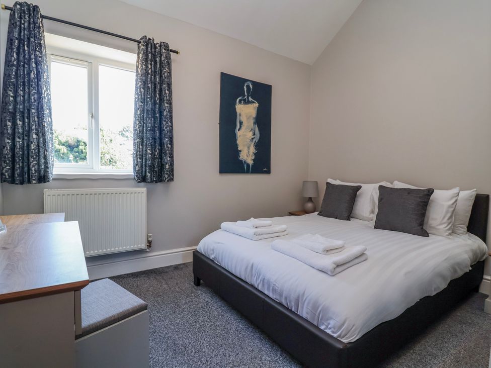 A bedroom with a bed and a desk at Elwy Cottage in St Asaph