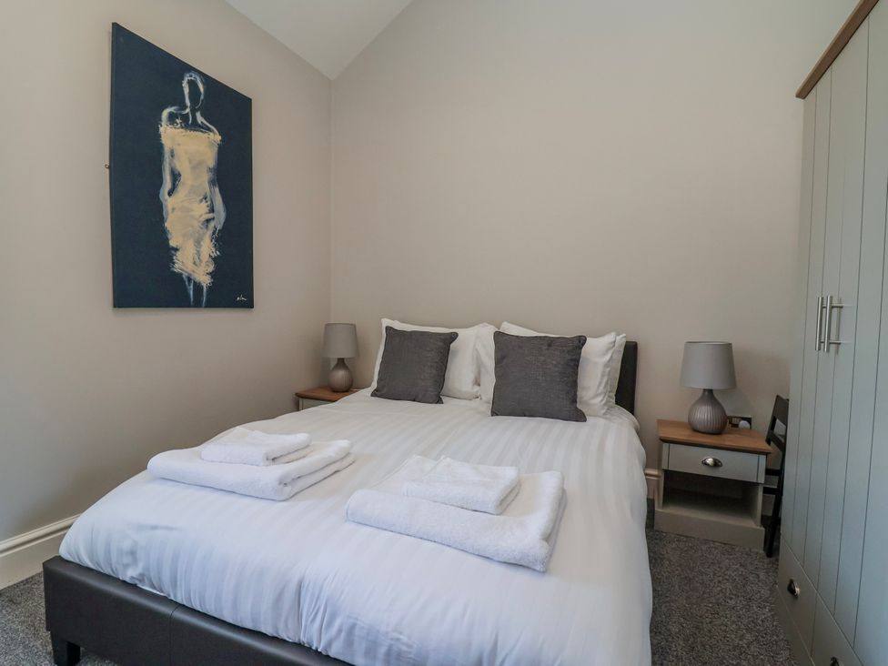 A bedroom with a bed and towels on it at Elwy Cottage in St Asaph