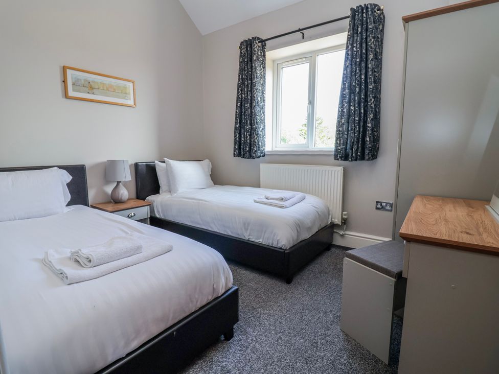 A bedroom with two beds and a desk at Elwy Cottage in St Asaph