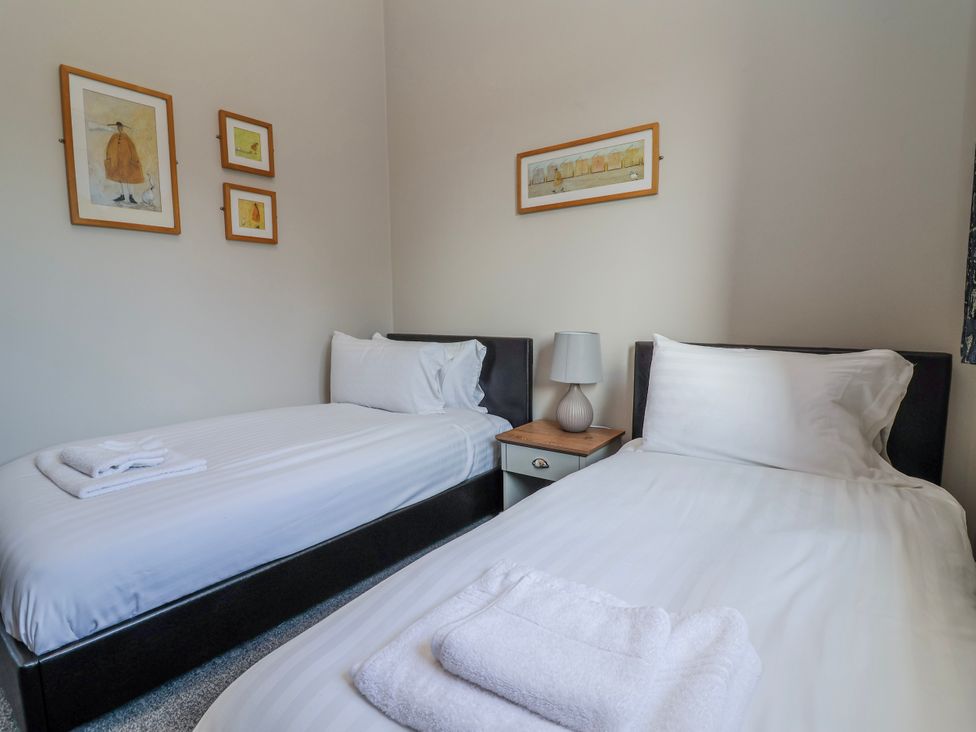 A bedroom with twin beds and a bedside table at Elwy Cottage St Asaph