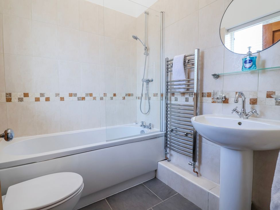 A bathroom featuring a shower above a bath at Elwy Cottage in St Asaph