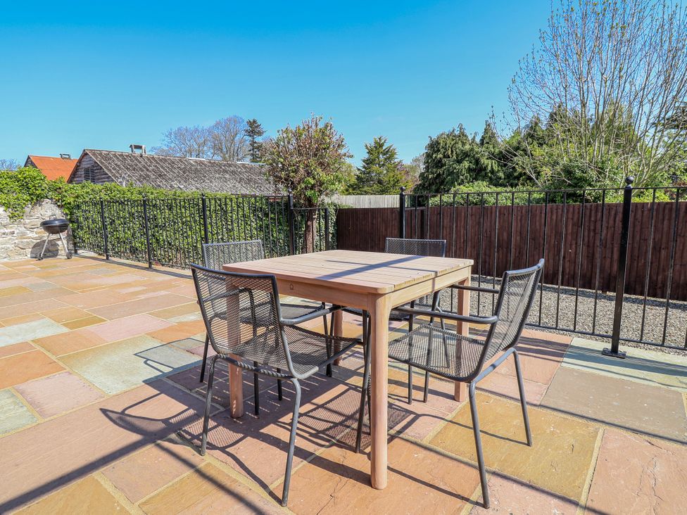 A patio with a table and chairs at Elwy Cottage St Asaph