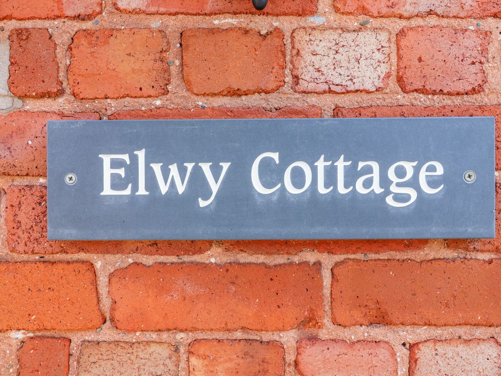 A nameplate on a brick wall at Elwy Cottage in St Asaph