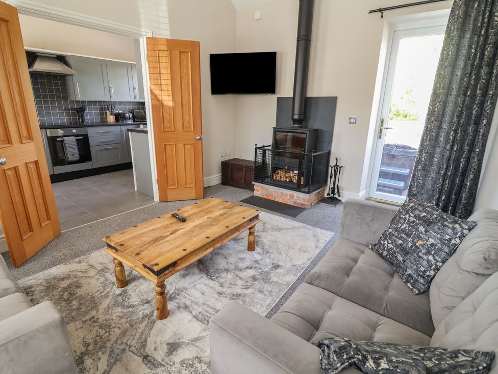 A living room with a fireplace and sofa at Elwy Cottage in St Asaph