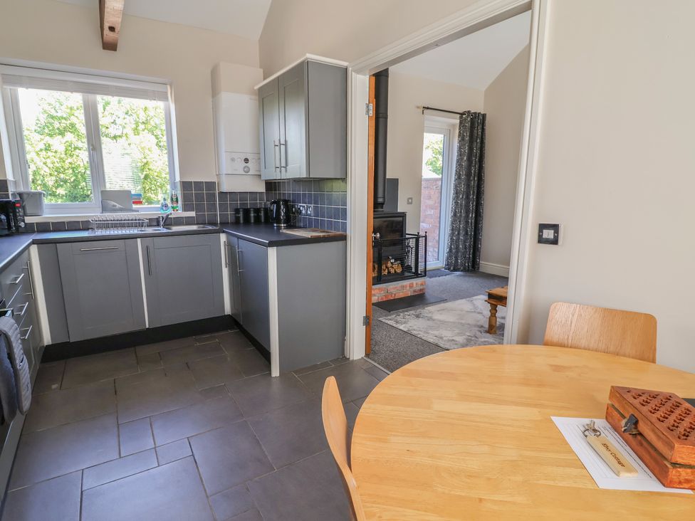 A kitchen with a table and chairs at Elwy Cottage in St Asaph