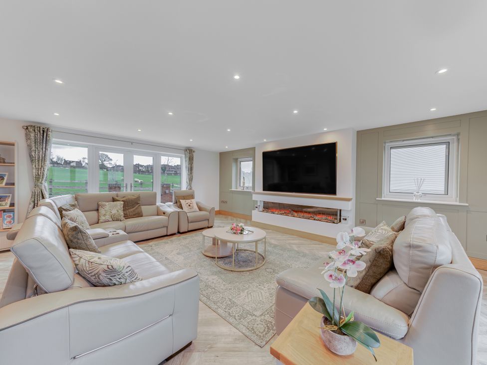 A living room with a television and fireplace at Greenacres Farm in Harriseahead near Mow Cop