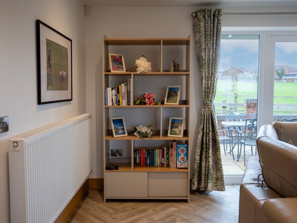 A living room with a bookshelf and seating area at Greenacres Farm Harriseahead near Mow Cop