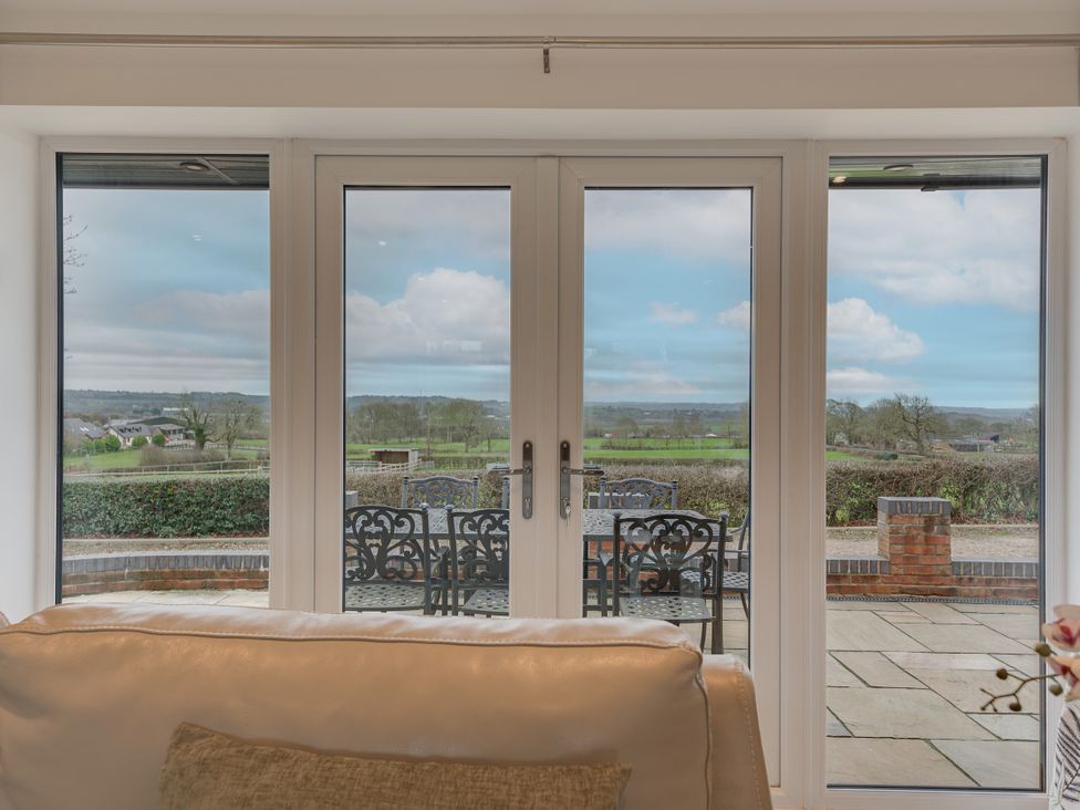 A living room with sliding glass doors and a view at Greenacres Farm Harriseahead near Mow Cop