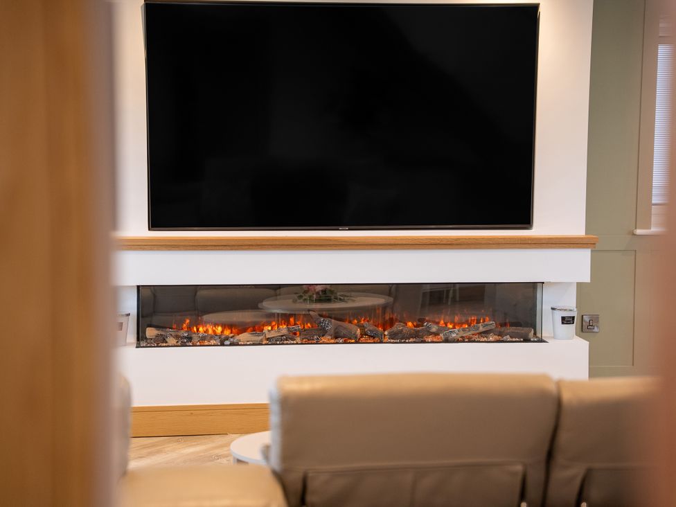 A living room with a television and a fireplace at Greenacres Farm in Harriseahead near Mow Cop