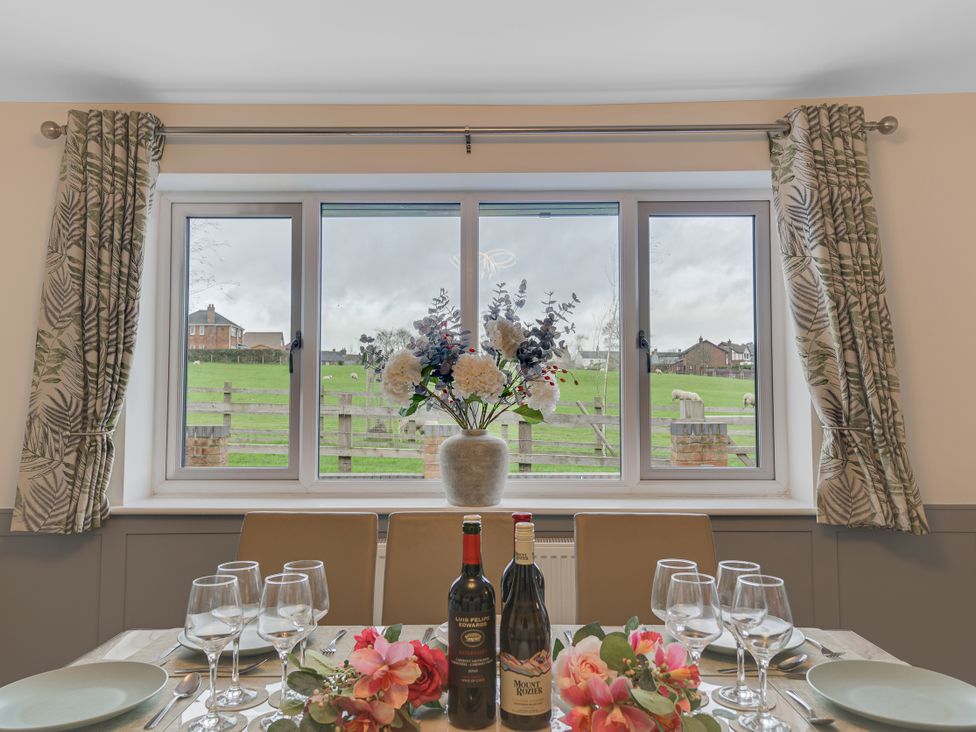 A dining room with a window overlooking a field at Greenacres Farm Harriseahead near Mow Cop