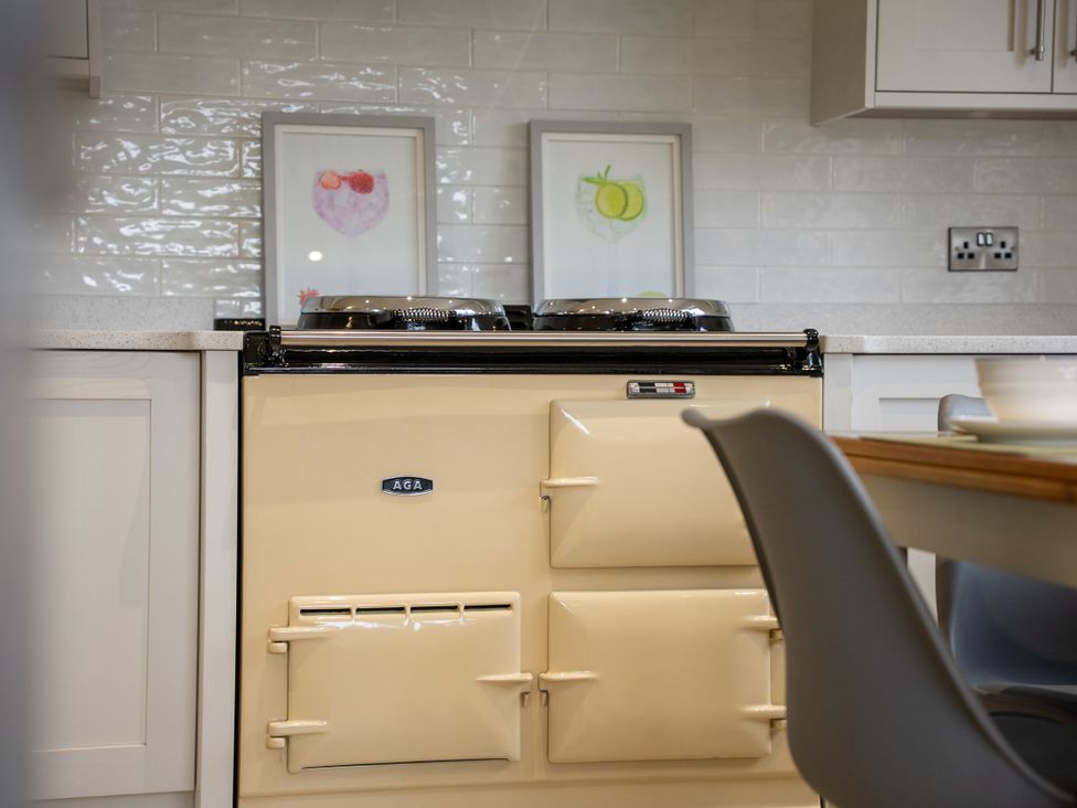 A kitchen featuring an AGA cooker and artwork on the wall at Greenacres Farm Harriseahead near Mow Cop