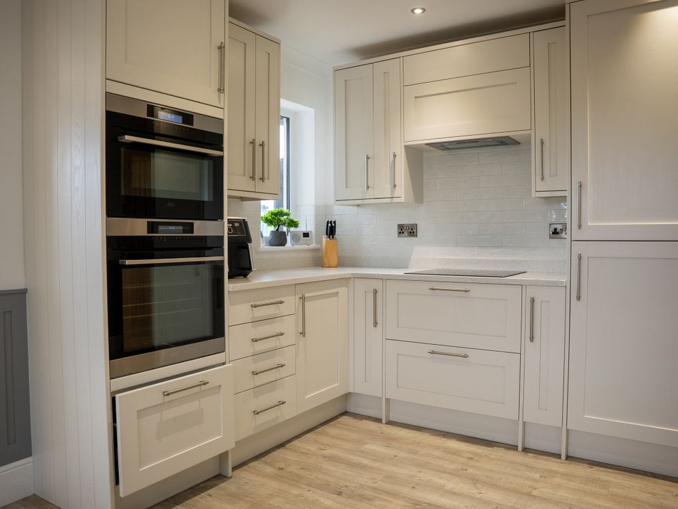 A kitchen with built-in appliances and cabinets at Greenacres Farm in Harriseahead near Mow Cop