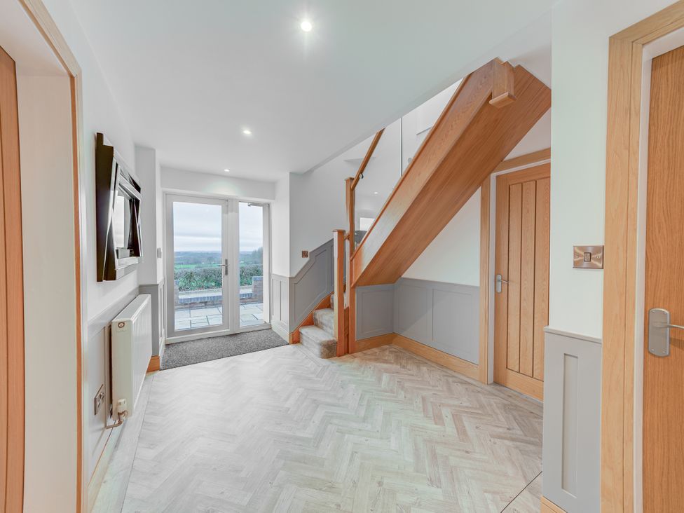 A hallway with a staircase and double doors at Greenacres Farm Harriseahead near Mow Cop