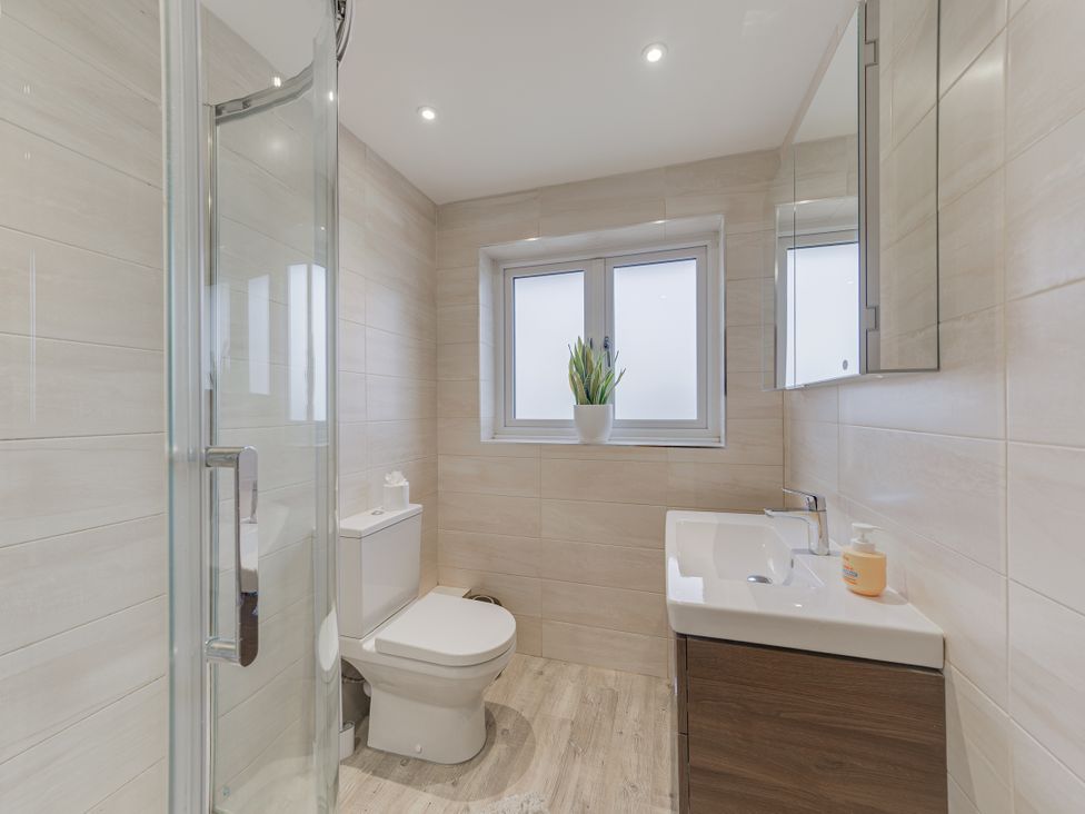 A bathroom with a shower, toilet, sink and window at Greenacres Farm in Harriseahead near Mow Cop