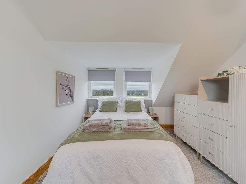 A bedroom with a bed and dresser at Greenacres Farm in Harriseahead near Mow Cop